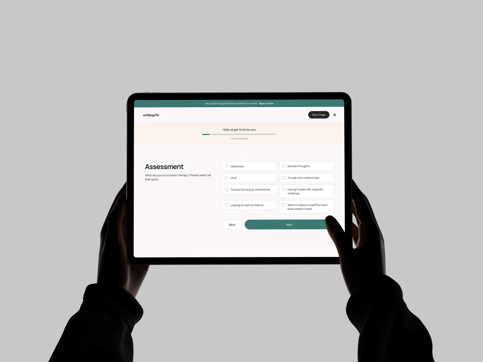 Two hands holding a tablet showing the WellPsyche enrollment assessment: &ldquo;Help us get to know you&rdquo; at 10% complete, with the reasons-for-therapy checklist laid out in two columns